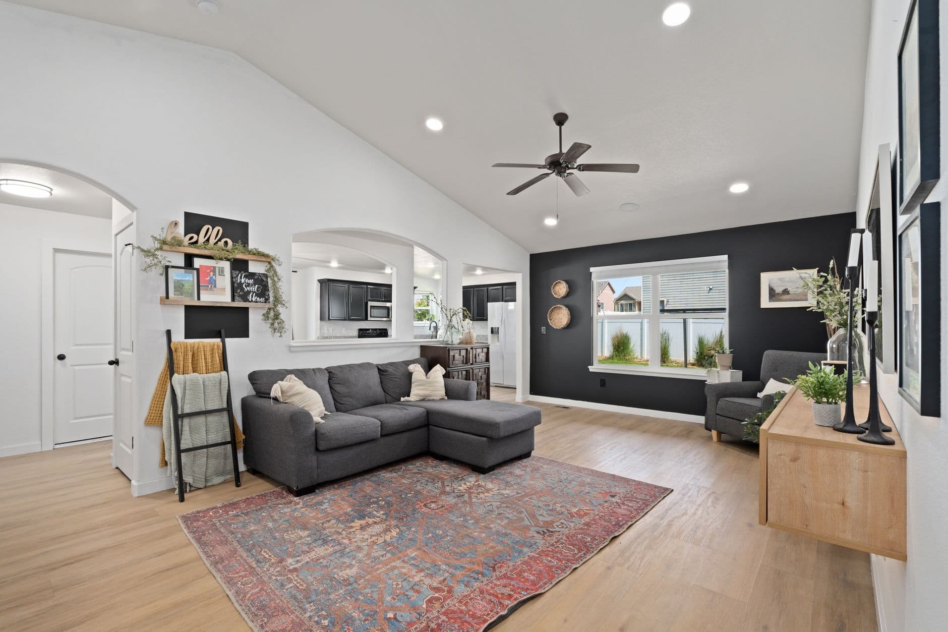 Spacious living room featuring a gray couch, vibrant rug, and modern decor for a cozy ambiance.
