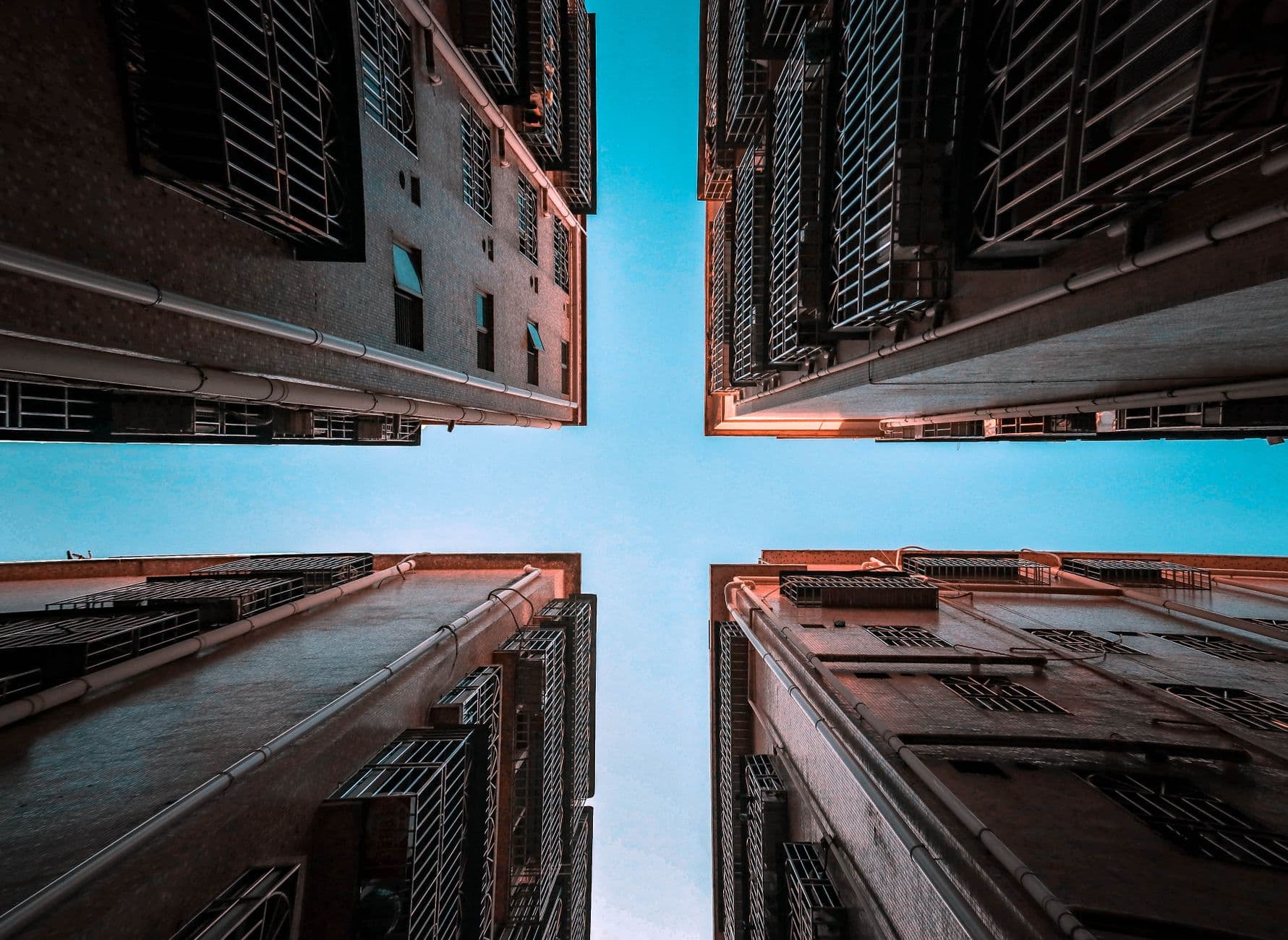A stunning low-angle shot of high-rise buildings against a clear blue sky.