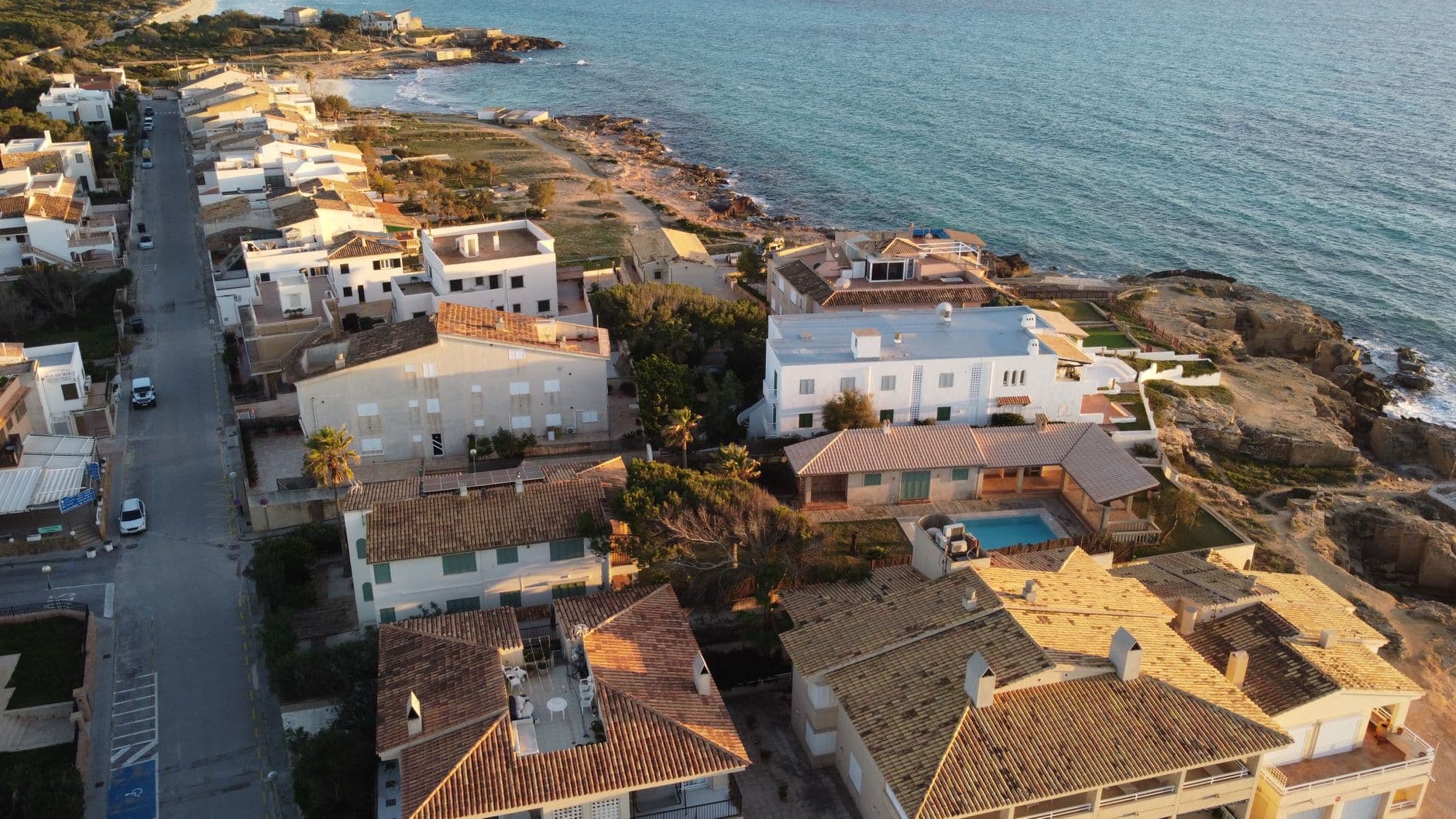 Scenic aerial view of seaside houses in Ses Covetes, Spain, capturing the Mediterranean vibe.