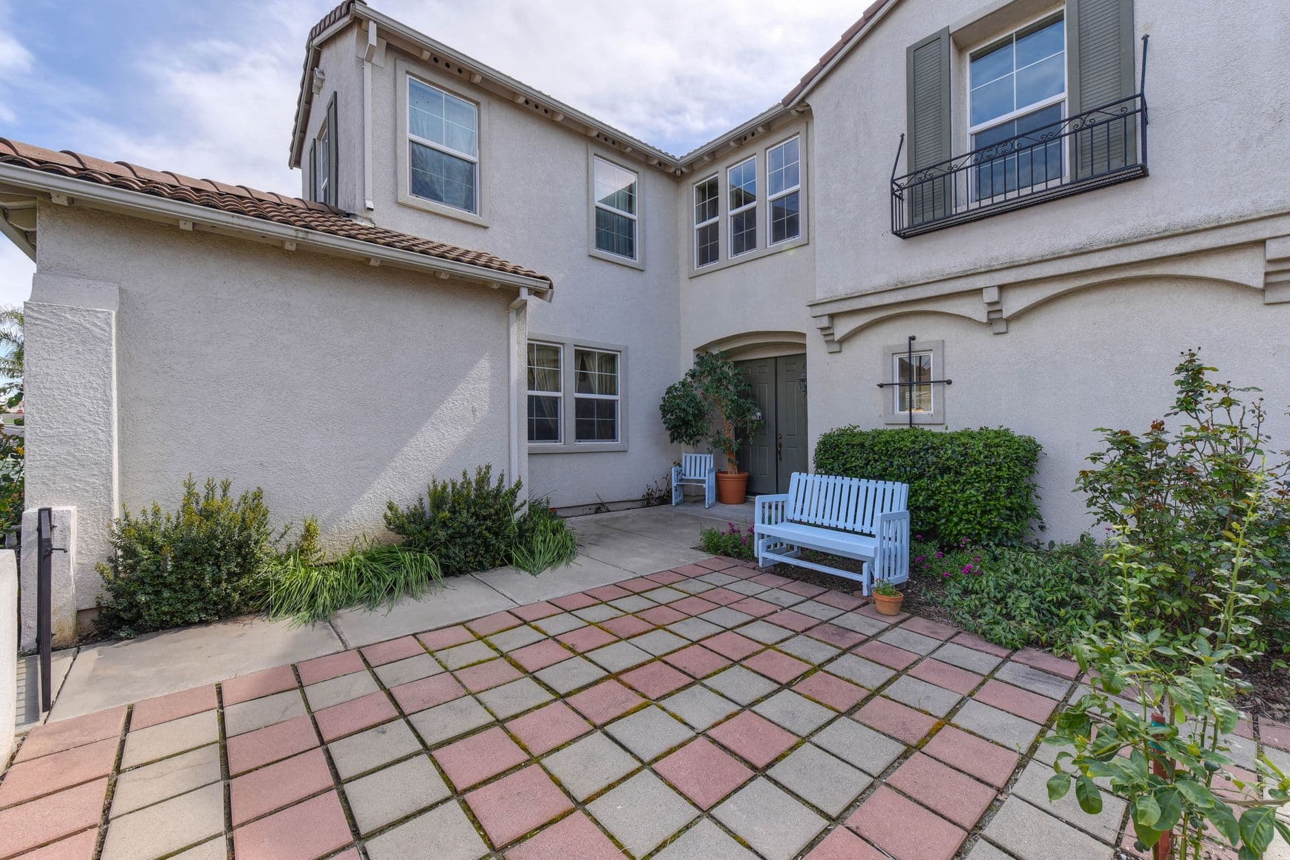 Elegant suburban home with a cozy patio area and vibrant garden.