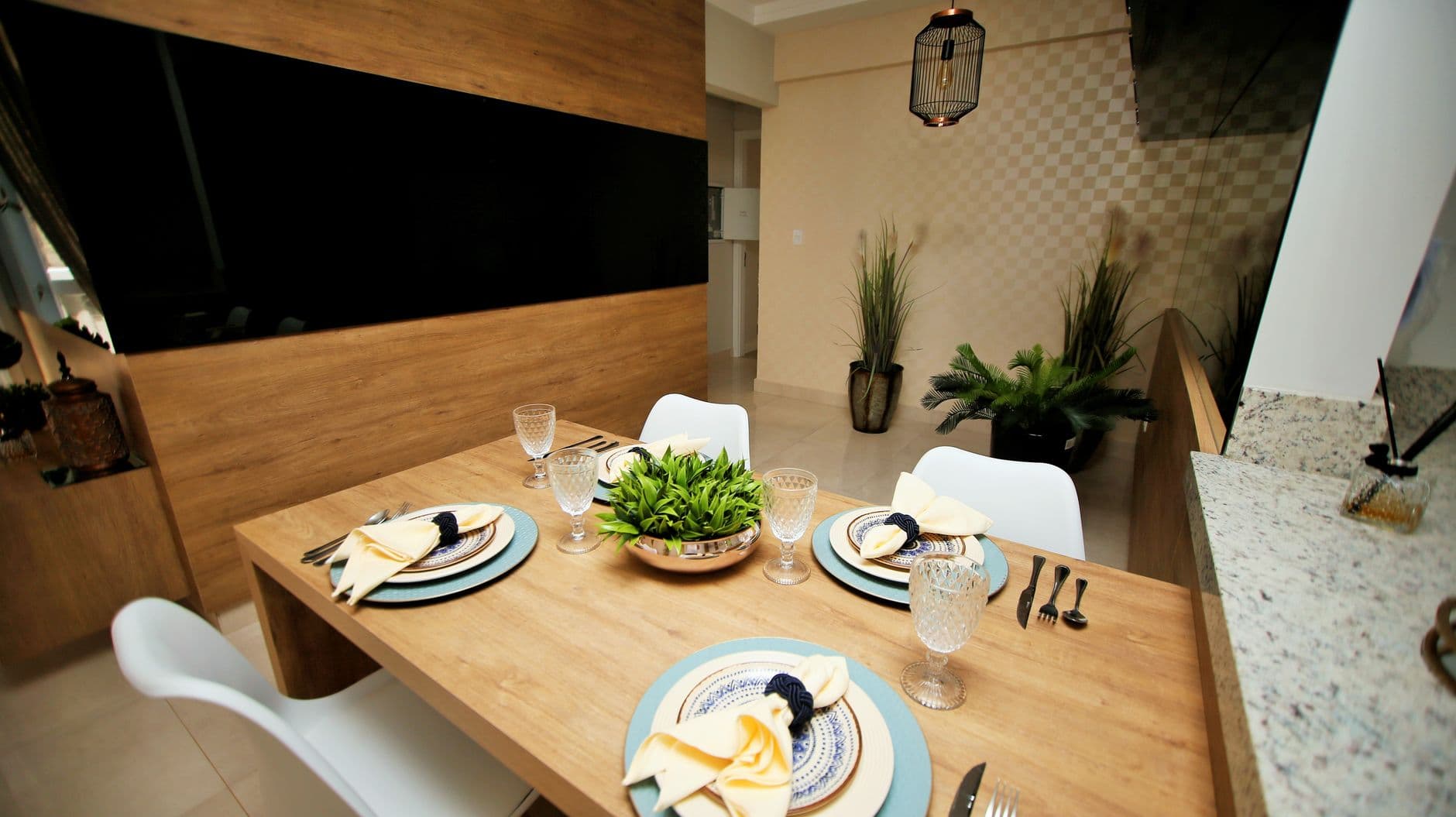Contemporary dining area featuring a stylish wooden table set with elegant crockery and glassware.