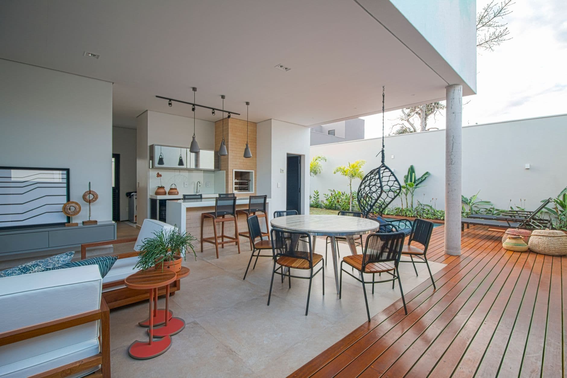 Contemporary open-plan patio with kitchen and seating area, modern design.