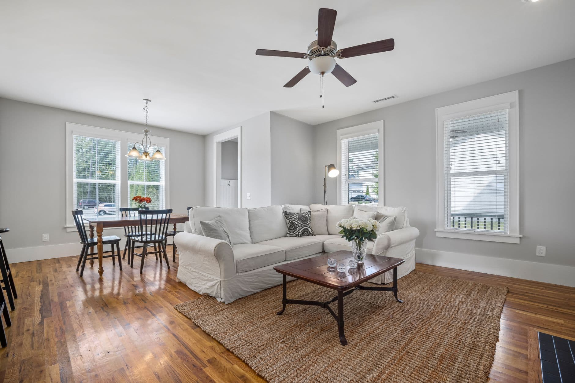 Bright open concept living room with wooden flooring and modern decor.