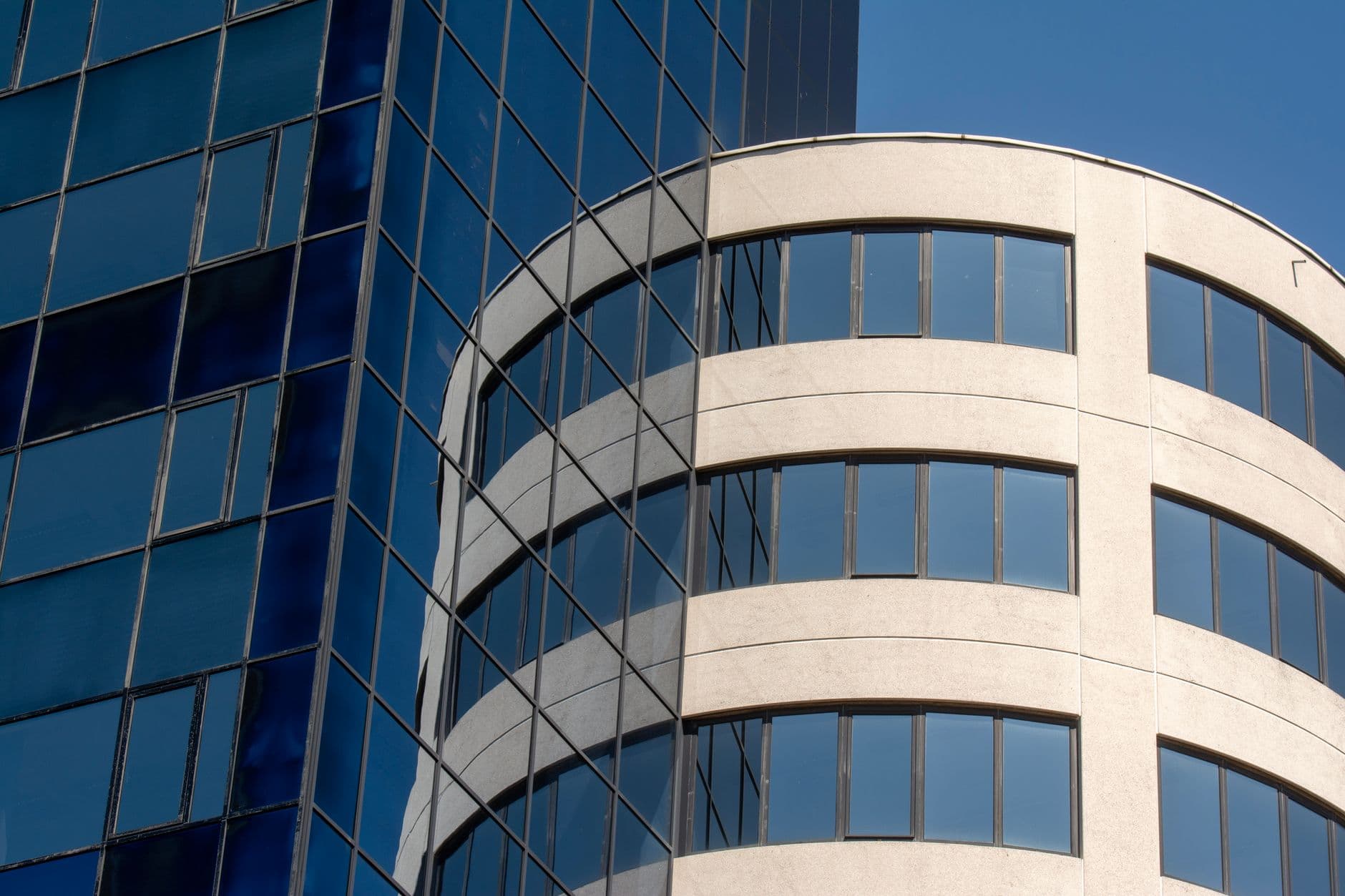 Close-up of modern building facade showcasing blend of glass and concrete elements.